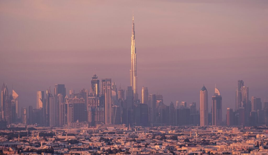 Vista panorámica de Dubái al atardecer con el Burj Khalifa y rascacielos iluminados, ideal para planificación de viajes.