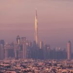 Vista panorámica de Dubái al atardecer con el Burj Khalifa y rascacielos iluminados, ideal para planificación de viajes.