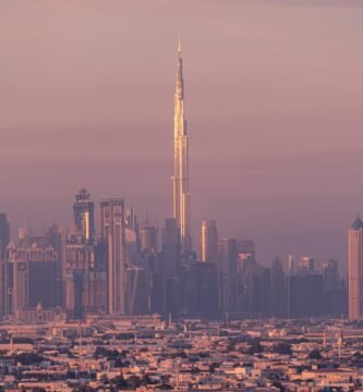 Vista panorámica de Dubái al atardecer con el Burj Khalifa y rascacielos iluminados, ideal para planificación de viajes.