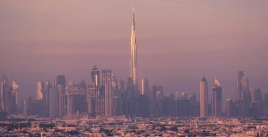 Vista panorámica de Dubái al atardecer con el Burj Khalifa y rascacielos iluminados, ideal para planificación de viajes.
